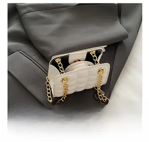 Vue détaillée de l'intérieur d'un sac matelassé blanc avec chaîne et cosmétiques