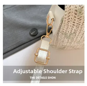Close-up of adjustable leather strap and gold hardware on woven floral saddle bag