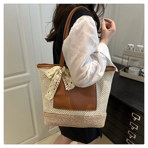 Detail of woven straw bucket bag with leather pocket and delicate lace bow