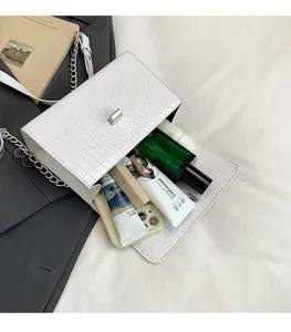 Vista interna della borsa bianca che mostra spazio per telefono, profumo e rossetto