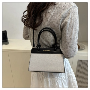 Détail du sac à main en toile contrastée avec poignée à nœud élégante et logo doré chic