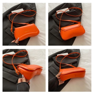 Detail view of the orange PU leather handbag showing texture and fine stitching