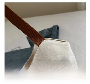 Detail of minimalist canvas tote with premium brown woven handle and textured fabric