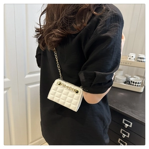 Détail du sac à bandoulière matelassé blanc avec chaîne dorée et texture cuir