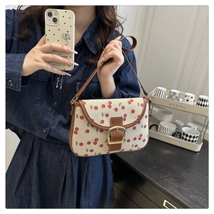 Vue détaillée du sac à bandoulière en toile avec motif cerise et bordure en cuir