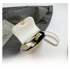 Interior capacity detail of a white woven crossbody bag with phone and cosmetics
