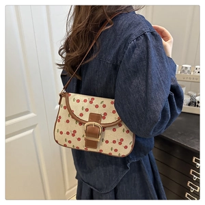 Vue détaillée du sac sous le bras en toile à motif cerises avec boucle dorée vintage