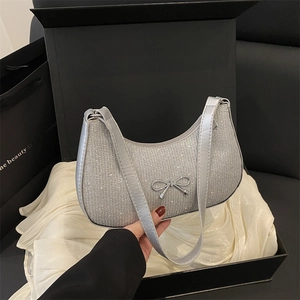 Silver glitter crescent shoulder bag with metallic bow detail and luxury gift packaging
