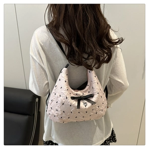 Vue arrière d'un mannequin portant un sac matelassé rose avec un grand nœud noir décoratif