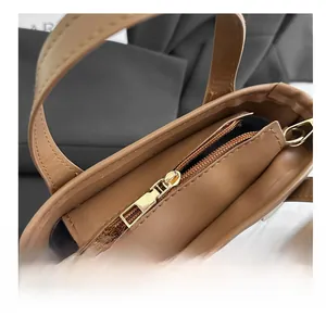 Detailed top view of caramel brown bucket bag showing internal smooth metal zipper and D-ring