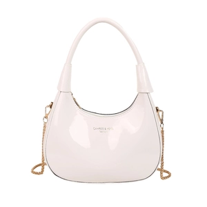 Glossy cream crescent hobo bag with a gold chain strap and top handle design
