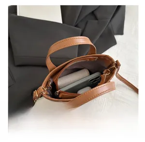 Top view showing the spacious interior of a brown leather bucket bag with daily items