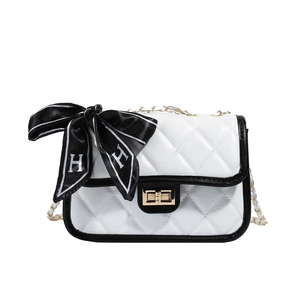 Quilted white crossbody bag with black trim and elegant golden chain strap