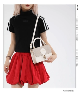 Detail of minimalist beige patchwork shoulder bag with gold metal buckle and leather logo