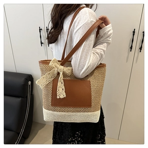Detail of hand-woven straw tote with leather pocket and delicate lace bow accent