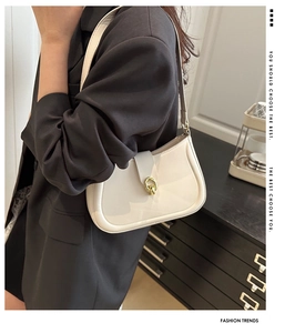 Detail of retro cream underarm bag with gold metal buckle and smooth faux leather texture