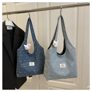 Detailed view of canvas tote bags featuring white bow patterns and cute plush pendants