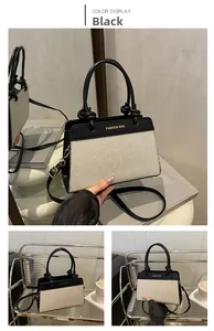 Detail of contrast stitch patchwork handbag with black leather handle and woven texture