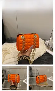 Détail du petit sac orange matelassé avec chaîne dorée et texture élégante moderne