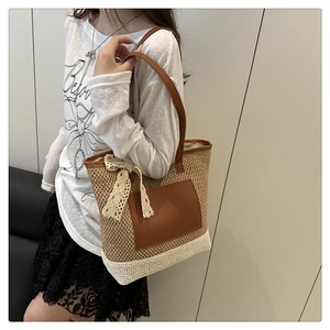 Détail du sac cabas en paille tissé avec poche en cuir et nœud décoratif en dentelle