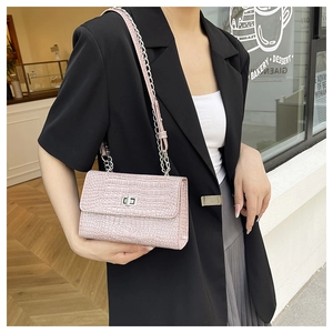 Dettaglio borsa rosa chiaro con motivo a coccodrillo, catena argento e chiusura