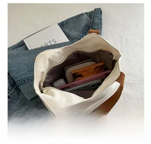 Detailed interior of a canvas tote bag showing roomy storage with items and a secure zipper