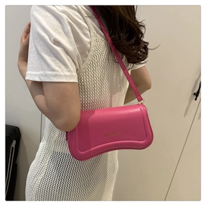 Rose pink crescent bag with fashion bags print worn by model in white dress