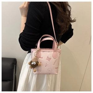 Pink PU leather bucket bag detail with butterfly embossing and plush animal charm