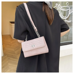 Détail du sac rose motif crocodile avec chaîne argentée et fermoir métallique élégant