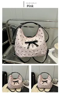 Détail du sac hobo rose à texture plissée, nœuds noirs et pendentif en forme de cœur
