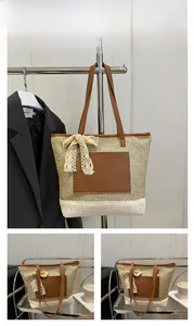 Détail du sac cabas en paille avec nœud en dentelle et poche en cuir marron