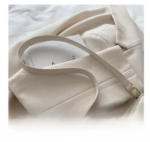 Detail of adjustable beige synthetic leather shoulder strap with gold metal buckle