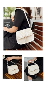 Detail view of beige saddle bag with vintage textured finish and metal buckle strap