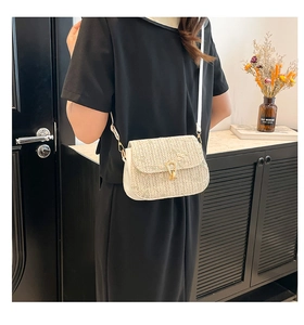Detail of floral embroidery on beige straw saddle bag with white PU leather trim