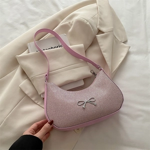 Pink glitter crescent hobo bag with silver bow charm and shoulder strap on soft blazer
