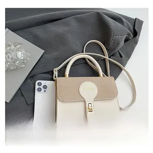 Detail of beige woven flap bag with gold lock and smartphone for size reference