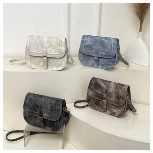 Detailed display of four retro saddle bags in cream, blue, black, and brown faux leather