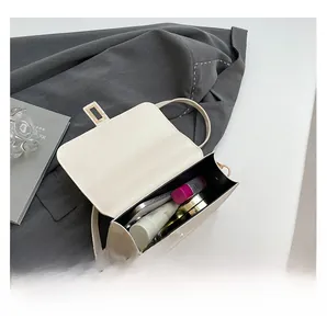 Top view showing the internal capacity of the off-white square crossbody bag with makeup
