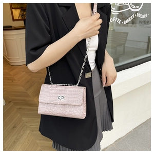 Sac à main rose effet crocodile avec fermoir rotatif argenté et bandoulière en chaîne