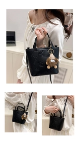 Detail of black embossed leather bucket bag with 3D floral motifs and lion plush charm