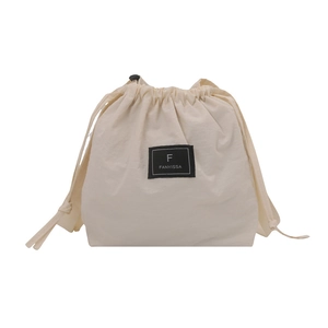 Minimalist beige drawstring bucket bag with black brand patch for casual summer style