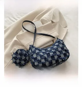 Dettaglio della borsa a tracolla in tweed a quadretti con bordi sfrangiati e mini borsellino