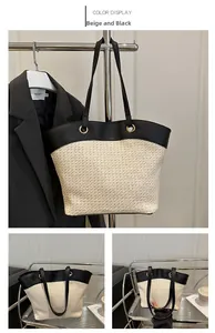 Close-up of beige woven tote bag with black faux leather trim and metallic rings