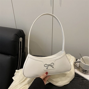 Chic white crescent underarm bag with silver bow accent on a luxury leather finish