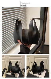 Detail view of black matte leather tote bag featuring elegant golden hardware accents