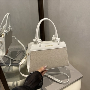 Sac à main chic avec panneaux contrastés, poignées et bandoulière amovible au style minimaliste
