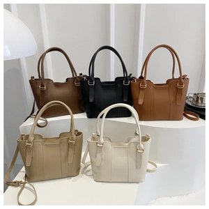 Collection of textured bucket bags in five colors with top handles and shoulder straps