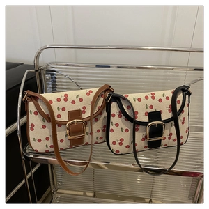 Détail de sacs bandoulière imprimé cerise avec boucles en fer à cheval vintage