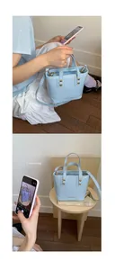 Close-up of light blue patent leather bucket bag with gold studs and adjustable strap