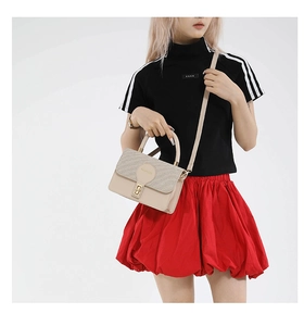 Détail du sac à main beige avec texture tissée et fermoir rotatif en métal doré